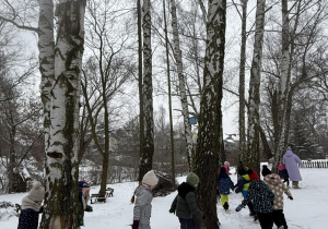 Dzieci biegają wokół drzew