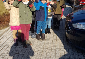 Dzieci przy znaku Jabłcusia na chodniku