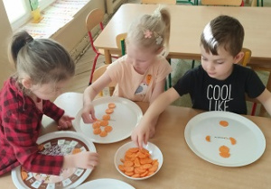 dzieci układaja marchewkowe wzory