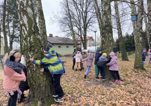 Dzieci przytulają się do drzew