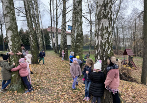 Dzieci przytulają się do drzew