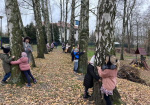 Dzieci przytulają się do drzew