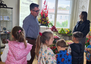 Pan opowiada dzieciom o wystawie