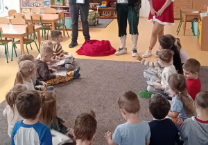 Dzieci siedzą na dywanie