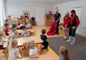 Dzieci siedzą przy stolikach