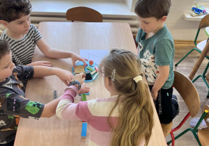 Dzieci wspólnie pracują przy stolikach