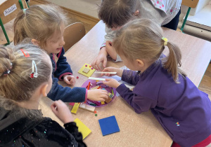 Dzieci wspólnie pracują przy stolikach