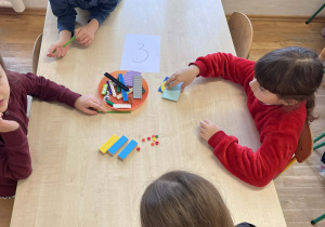 Dzieci wspólnie pracują przy stolikach