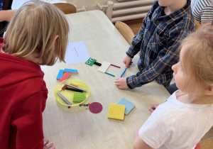 Dzieci wspólnie pracują przy stolikach