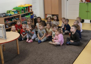 Dzieci siedzą na dywanie