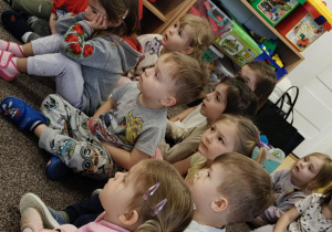 Dzieci siedzą na dywanie