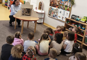 Dzieci siedzą na dywanie