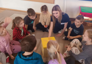 Dzieci siedzą na dywanie