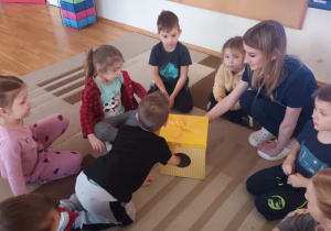 Dzieci siedzą na dywanie