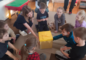 Dzieci siedzą na dywanie