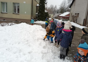 Dzieci biorą w ręce śnieg