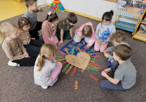 Dzieci siedzą na dywanie