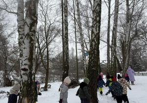 Dzieci biegają wokół drzew