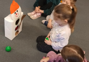 Dzieci siedzą na dywanie