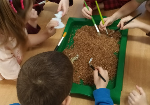 Dzieci siedzą przy stolikach