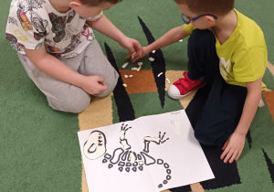 Dzieci układają na dywanie