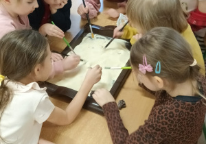 Dzieci siedza przy stolikach