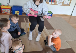 Dzieci słuchają ukulele