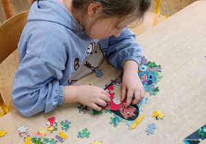 Dziewczynka układa puzzle