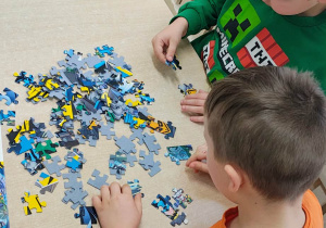 Chłopiec układa puzzle