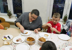 Dzieci z rodzicami dekorują pierniczki