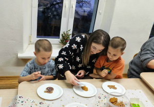 Dzieci z rodzicami dekorują pierniczki