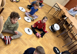 Dzieci siedzą na podlodze