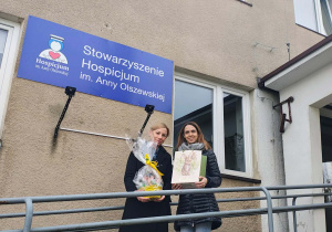 Panie z kartkami wchodzą do Hospicjum