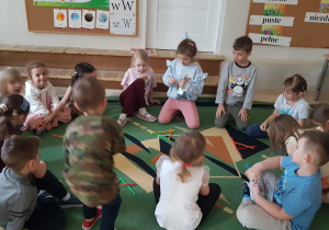 Dzieci siedzą na dywan