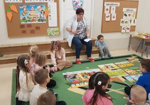 Dzieci siedzą na dywanie