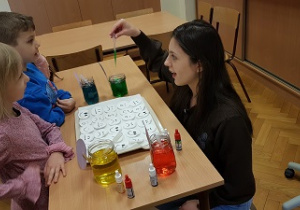 Dzieci stoją przy ławce