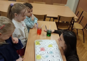 Dzieci stoją przy ławce