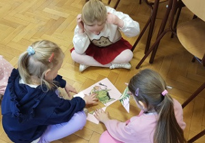 Dzieci siedzą na podłodze
