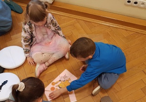 Dzieci siedzą na podłodze