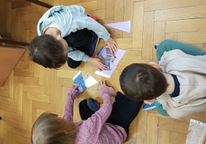 Dzieci siedzą na podłodze