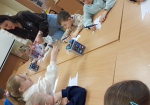 Dzieci siedzą na podłodze