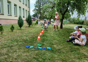 Dziewczynka toczy piłkę miedzy pachołkami