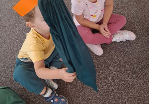 Dzieci siedzą na dywanie