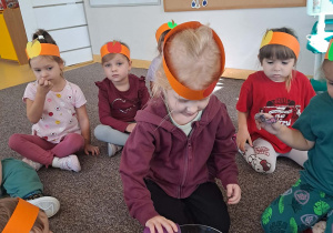 Dzieci siedza na dywanie
