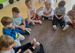 Dzieci siedza na dywanie