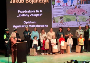 Scena z wręczenia nagród dla dzieci, w obecności nauczycieli i służb mundurowych