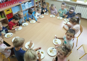 dzieci zajadają sałatkę z apetytem