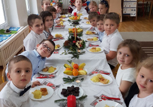 dzieci przed jedzeniem wigilijnego posiłku