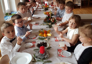 dzieci przy stole podczas życzeń z opłatkiem